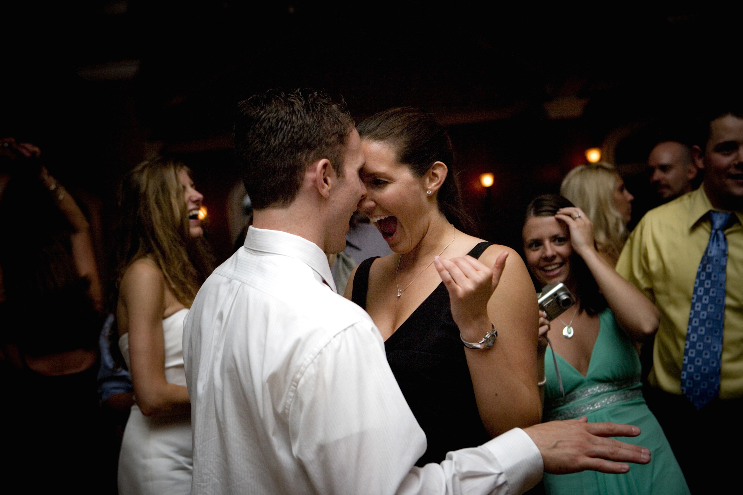 Couple dancing closely at a lively party.