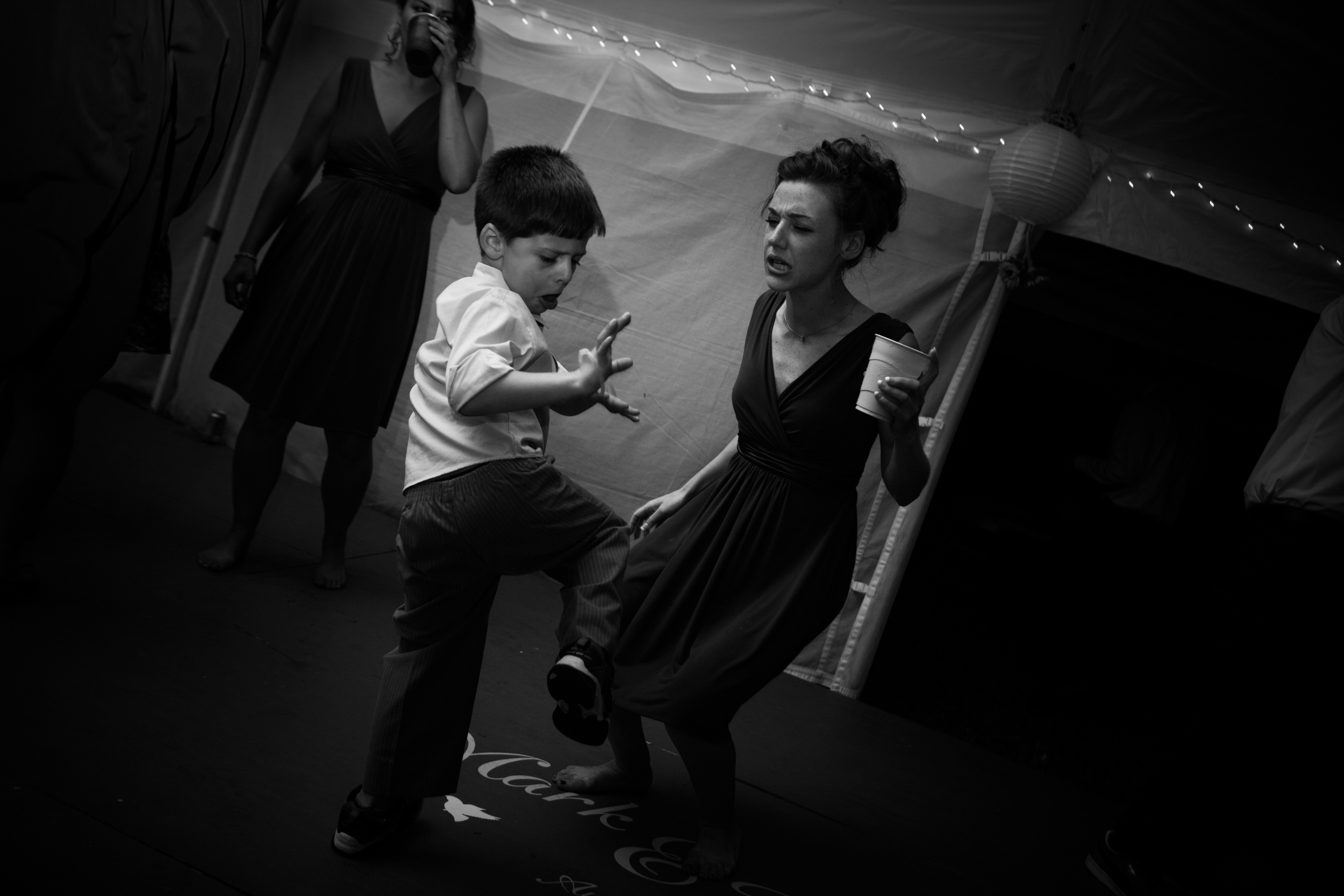 A woman and a boy dancing joyfully in black and white.