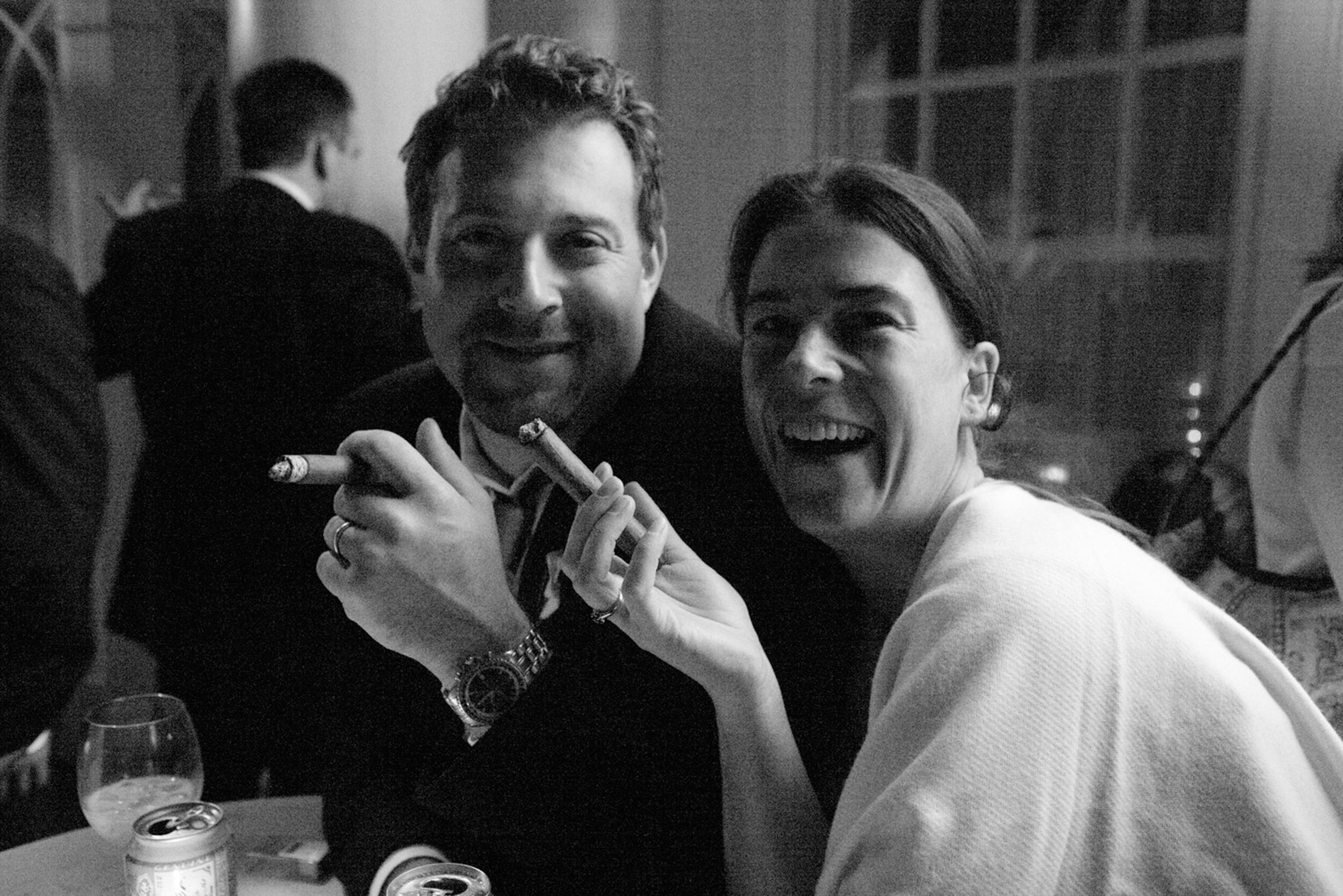 Two people smiling and holding guns, enjoying a moment together.