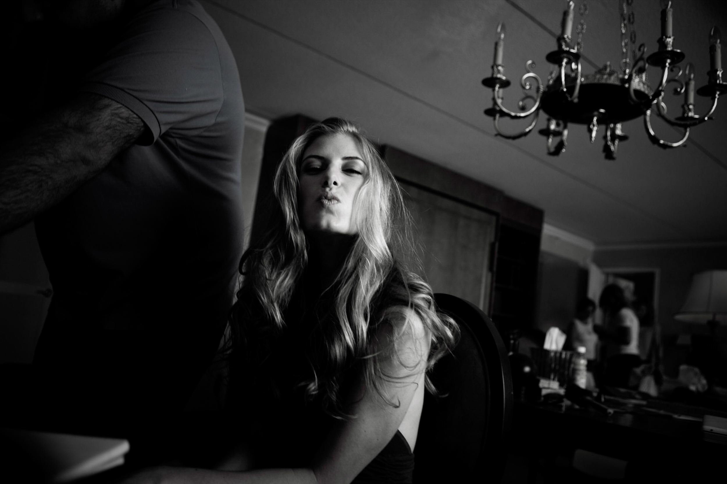 Black and white portrait of a woman with long hair in moody lighting.