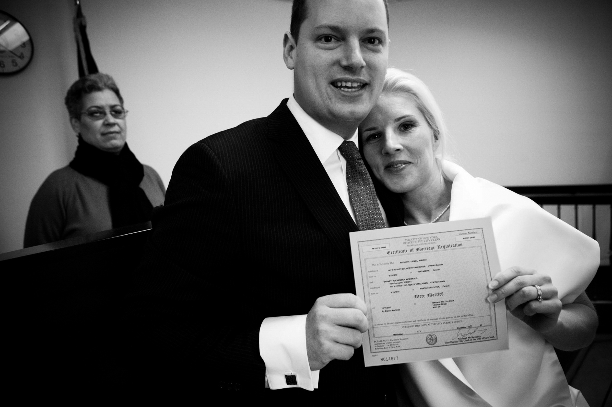 A smiling couple holding a certificate, celebrating an achievement.