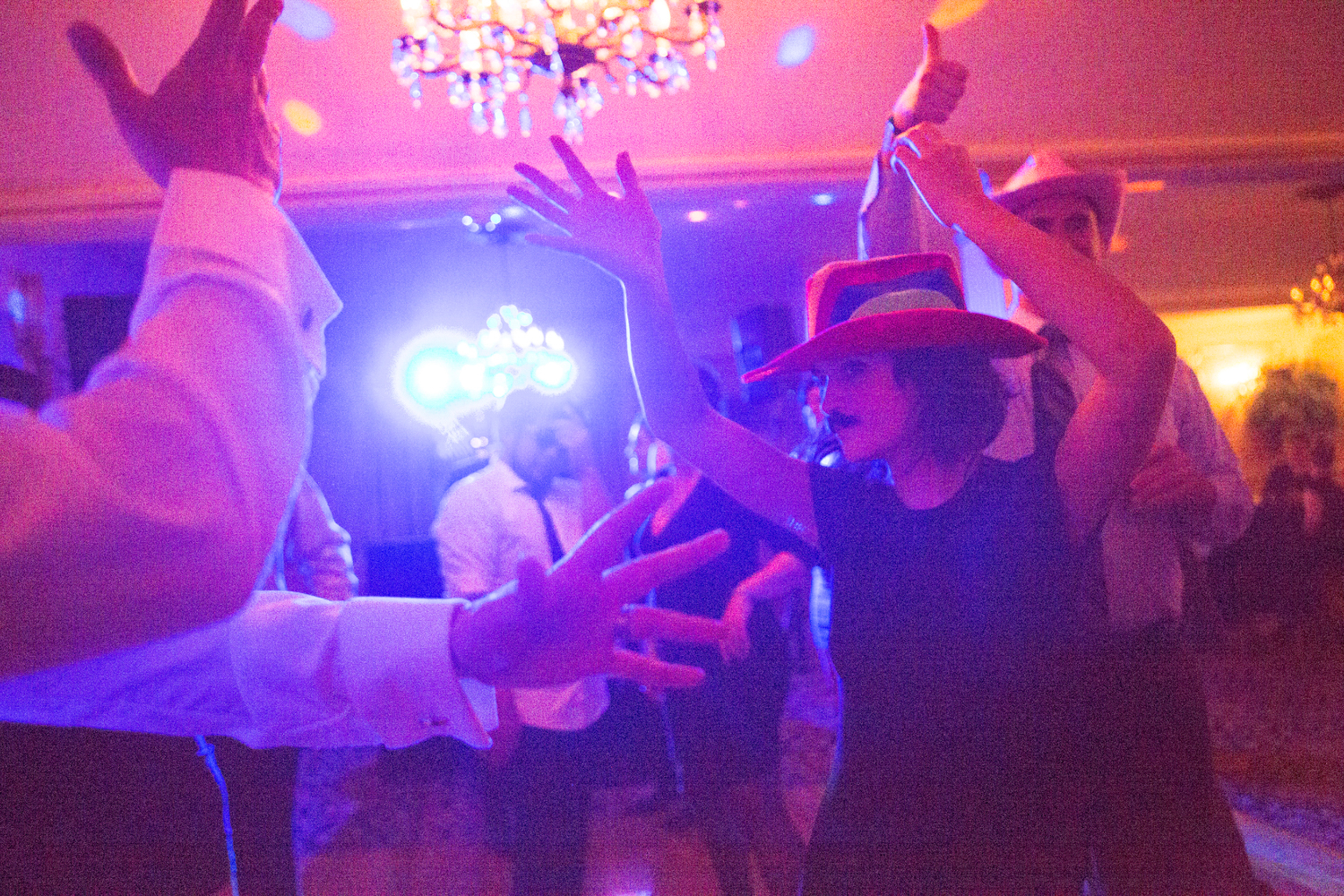 People dancing and enjoying a lively party with colorful lighting.