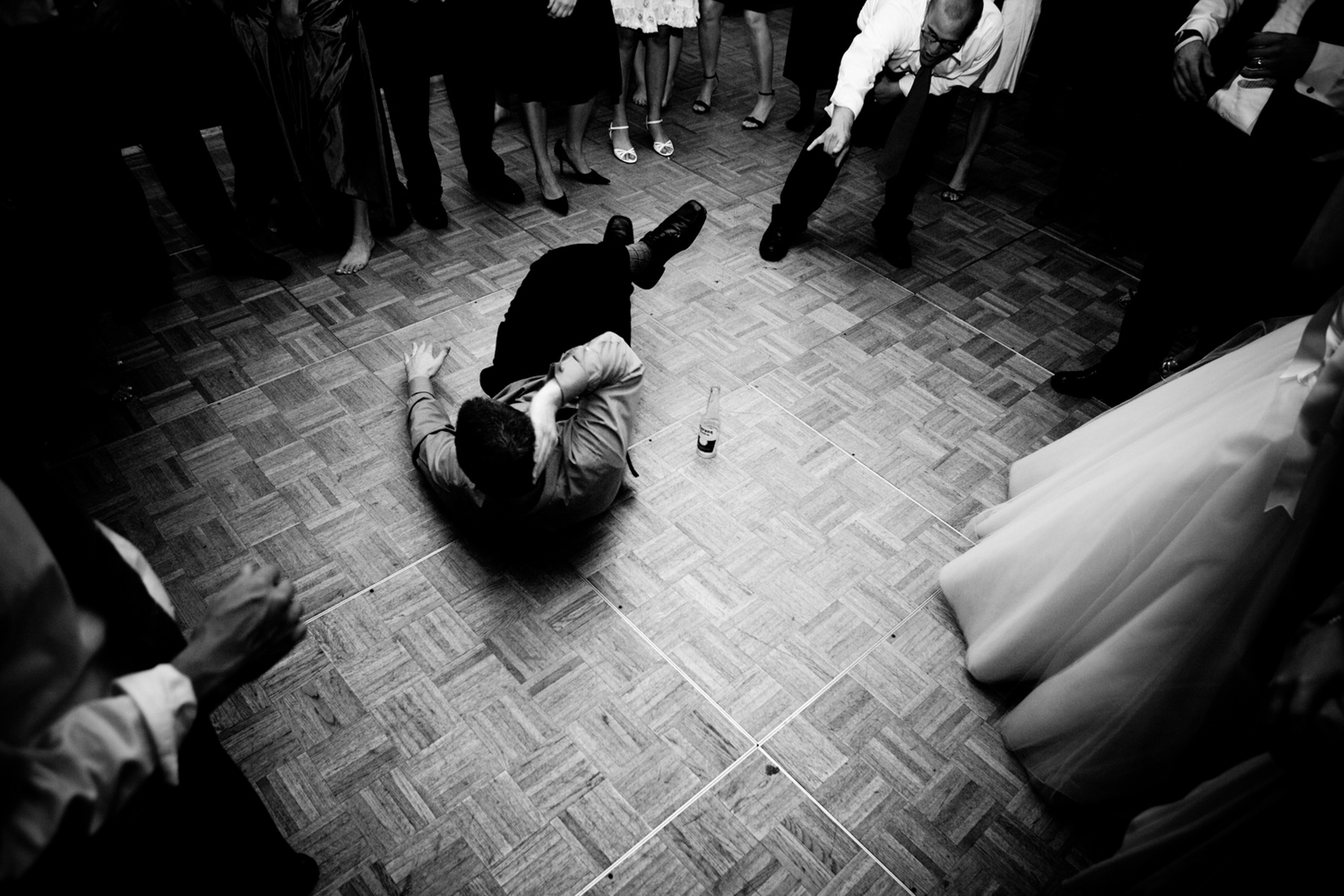Person falls or is pushed onto the dance floor amid a crowd.