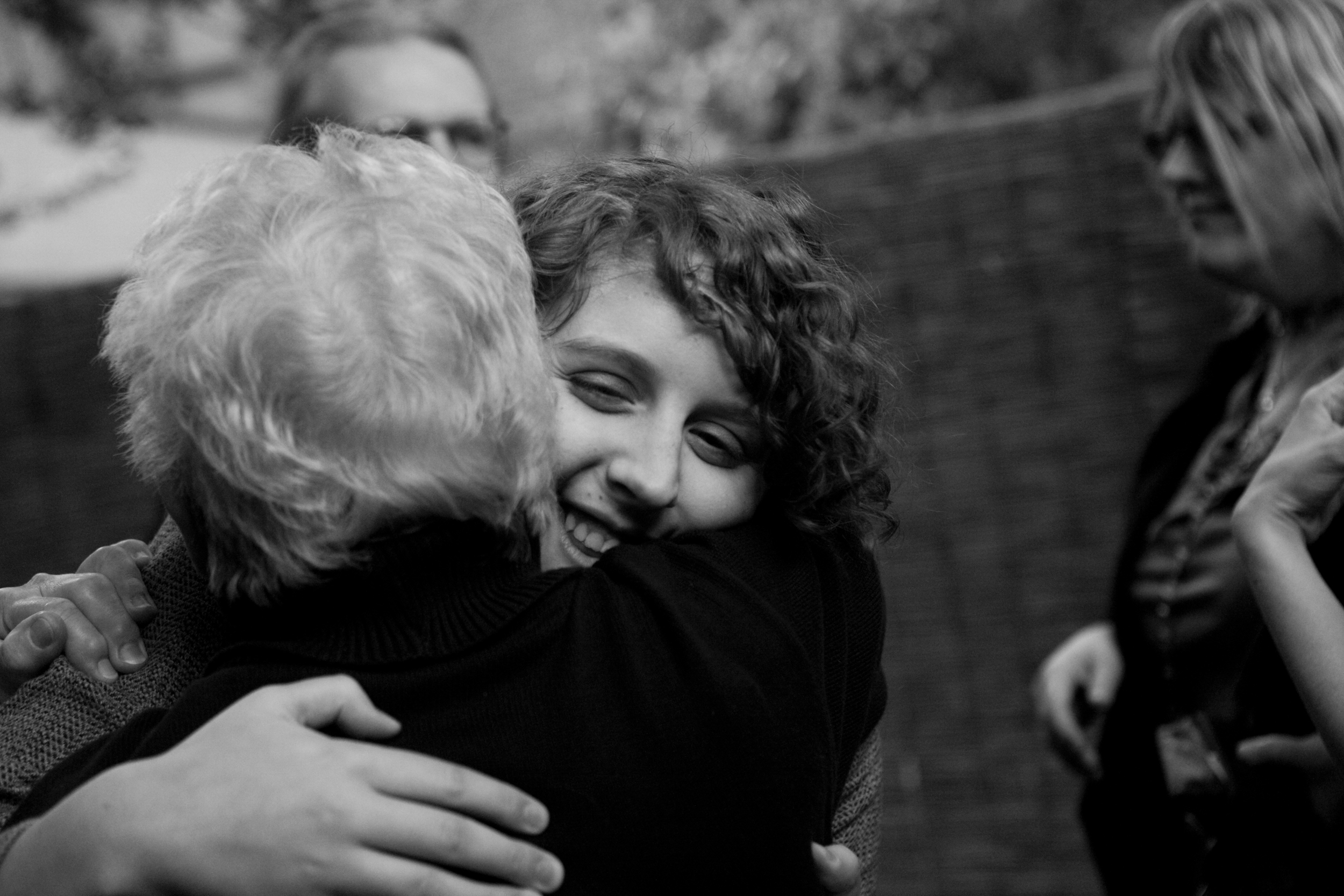 Two people embracing warmly in a black and white photo.