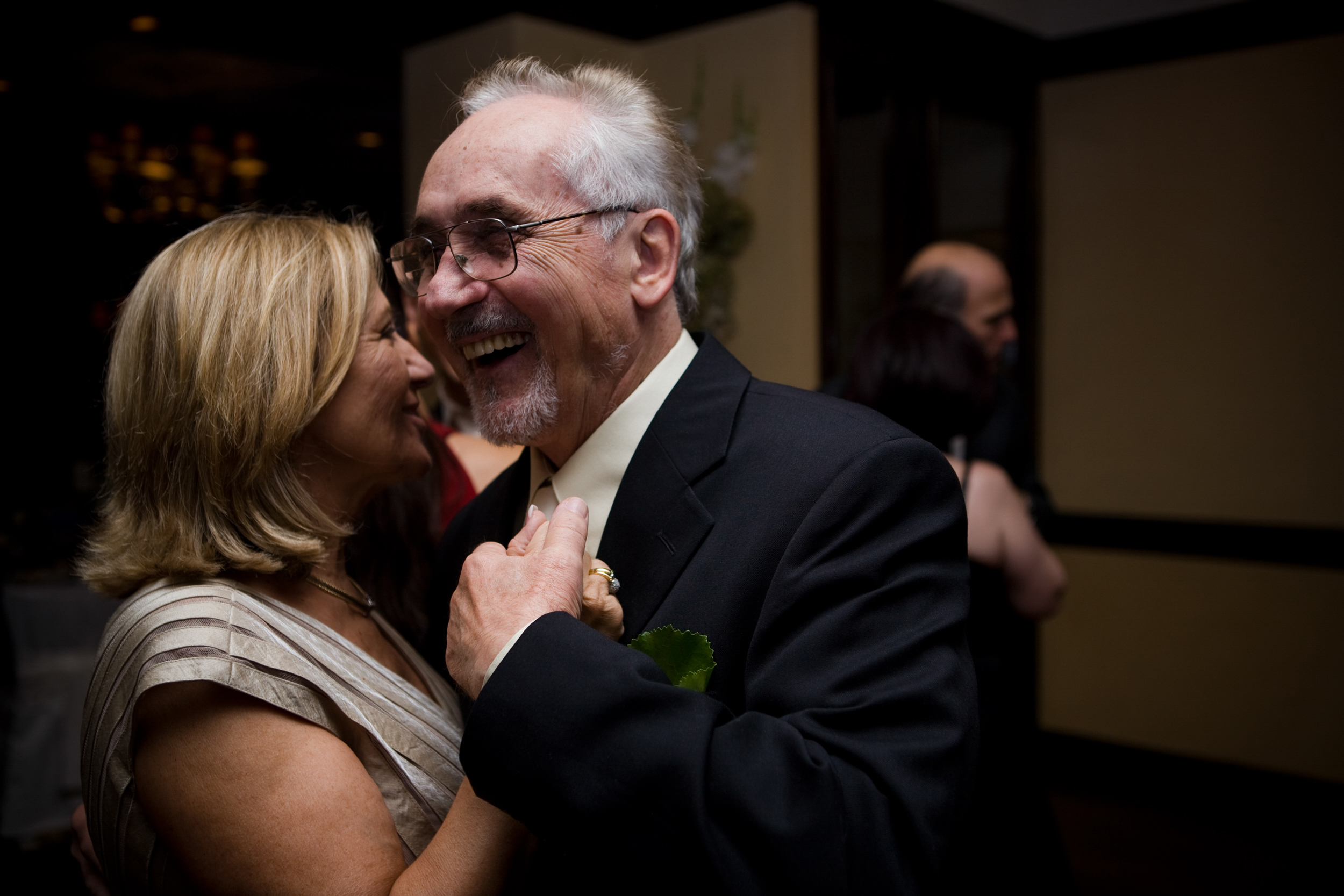 Elderly couple sharing a joyful dance at a formal event.