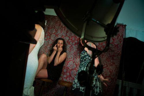 Two women laughing and enjoying themselves in a cozy, warmly lit room with vintage decor.