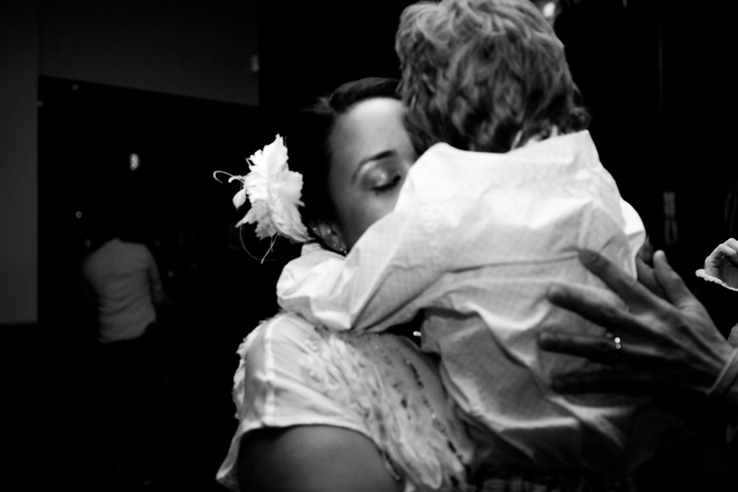 A woman affectionately holding a child in a black and white photo.