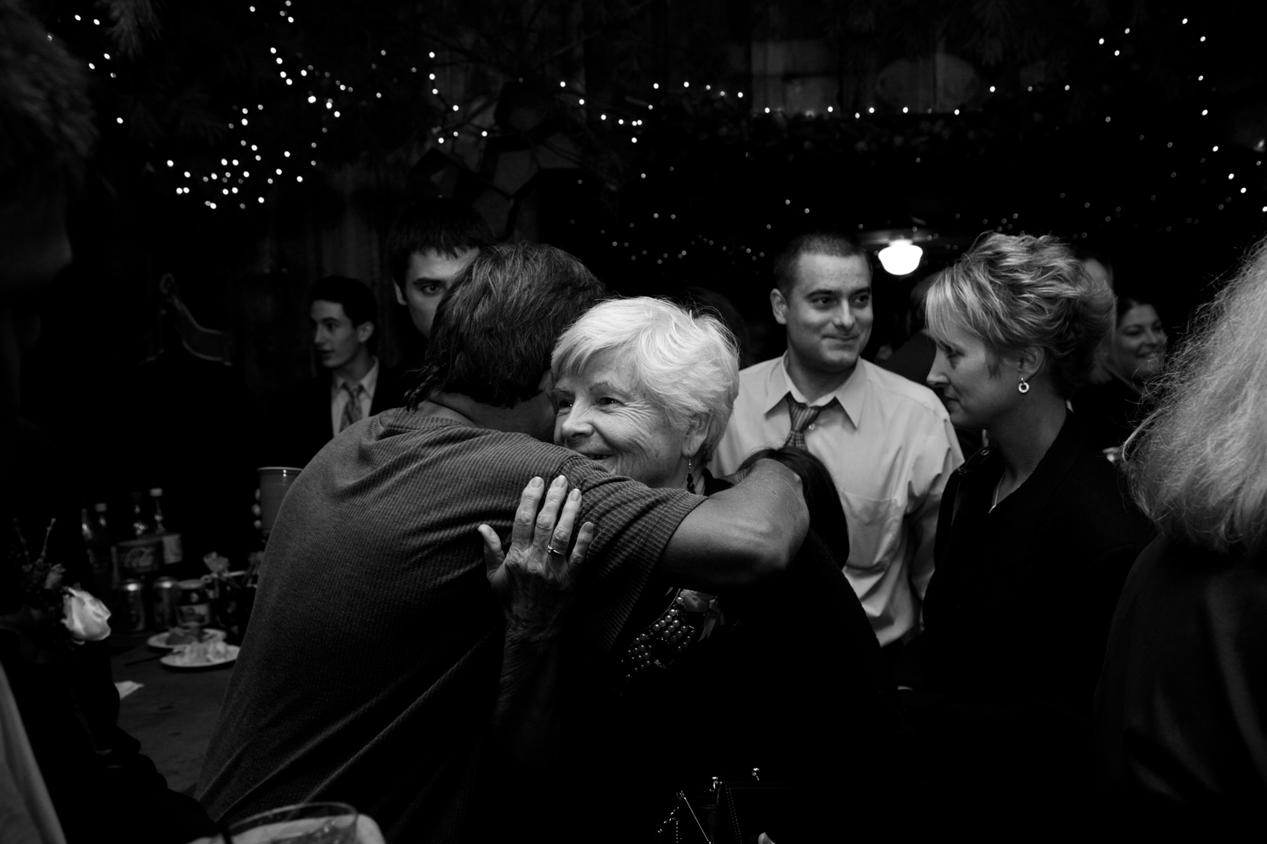 A warm hug shared between two people at a gathering.